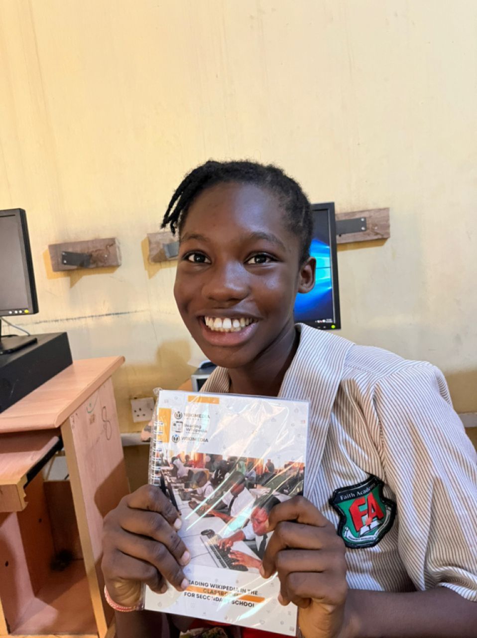 A female student holding the RWC quick guide with a wide smile on her face