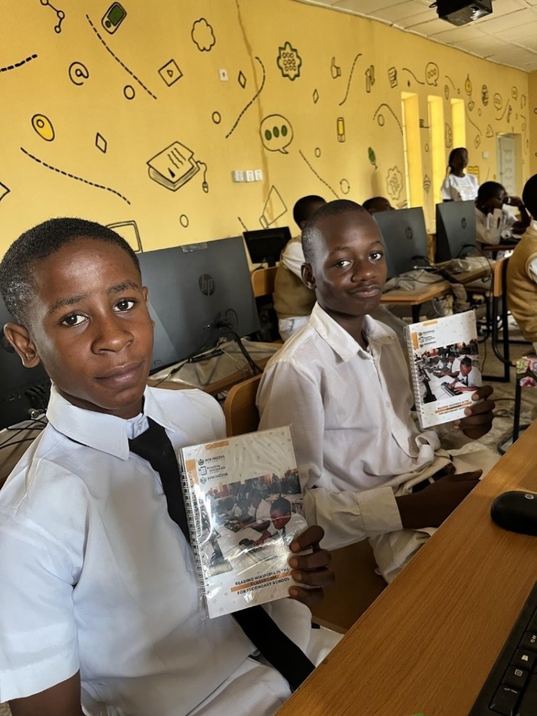 A photo of 2 male students holding the RWC Student quick guide at the Gvernment Secondary School Ilorin during the training session