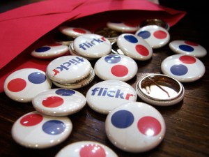 Several badges with Flickr's logos spread around a table and coming out of an envelope.
