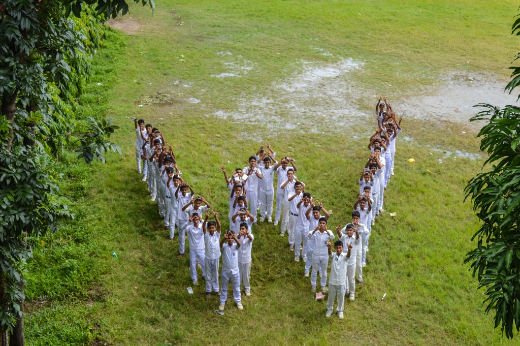 Students showing a 'W' sign during the school program held in 2015.