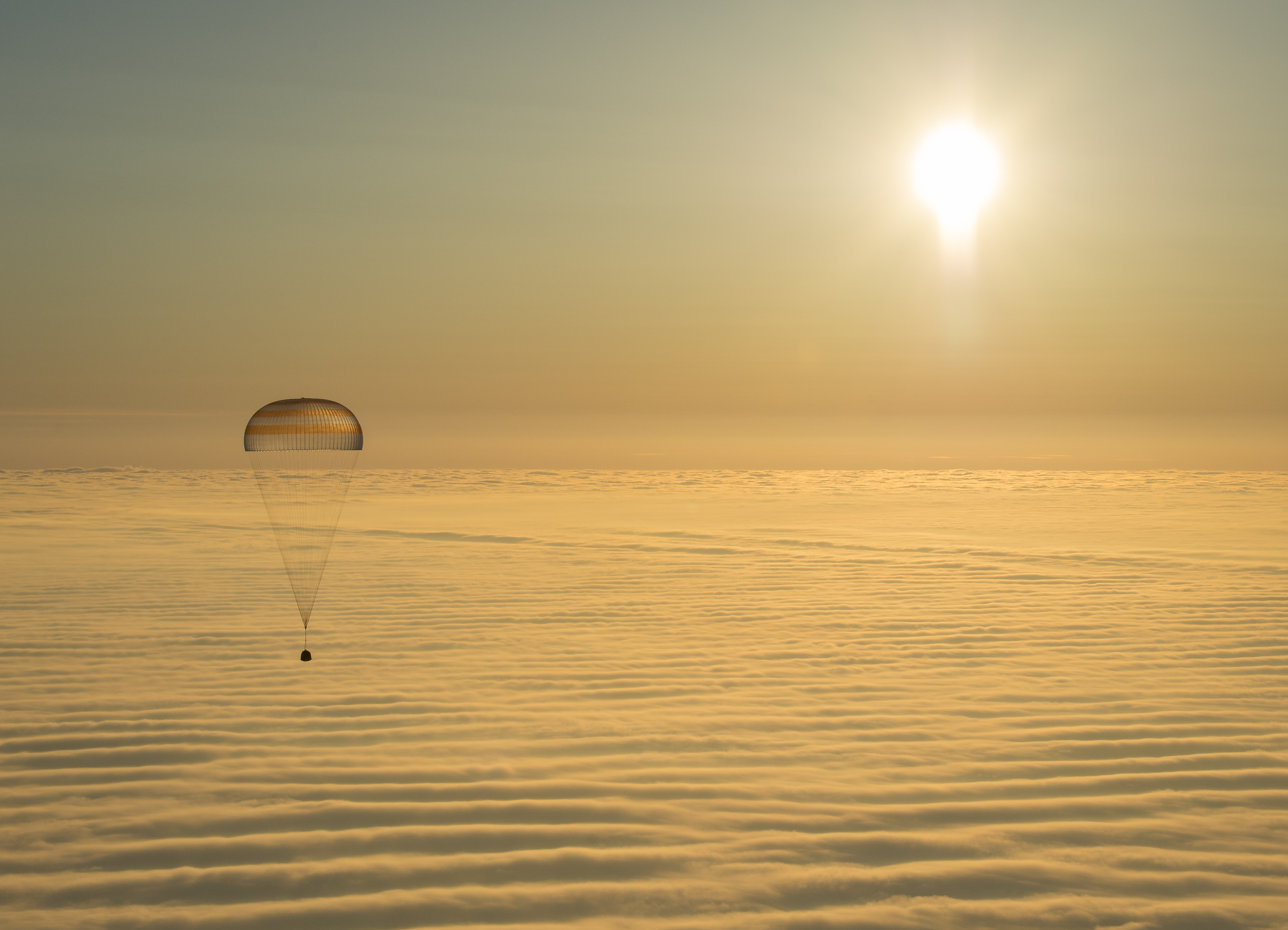 On March 12, 2015, shortly after local sunrise over central Asia, this Soyuz TMA-14M spacecraft floated over a sea of golden clouds during its descent by parachute through planet Earth's dense atmosphere. On board were Expedition 42 commander Barry Wilmore of NASA and Alexander Samokutyaev and Elena Serova of the Russian Federal Space Agency (Roscosmos). Touch down was at approximately 10:07 p.m. EDT (8:07 a.m. March 12, Kazakh time) southeast of Zhezkazgan, Kazakhstan. The three were returning from low Earth orbit, after almost six months on the International Space Station as members of the Expedition 41 and Expedition 42 crews